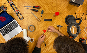 Deux étudiants en train de fabriquer des instruments à l’aide d’outils de menuiserie et d’un ordinateur